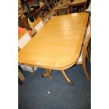 A MODERN LIGHT OAK TWIN PEDESTAL EXTENDING DINING TABLE AND FOUR CHAIRS