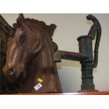 A RESIN HORSE HEAD TOGETHER WITH A CAST IRON WATER PUMP