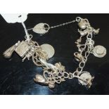 A SILVER CHARM BRACELET AND CHARMS