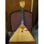 A VINTAGE TRADITIONAL THREE STRING INSTRUMENT