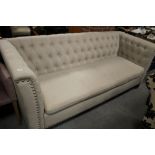 A MODERN UPHOLSTERED BUTTON BACK SOFA