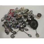 A COLLECTION OF SOUVENIR SPOONS TOGETHER WITH A SILVER TOPPED VANITY JAR, GERMAN CAR BADGE ETC