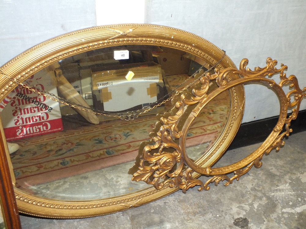 A GILT FRAMED VINTAGE OVAL WALL MIRROR TOGETHER WITH A METAL OVAL PICTURE FRAME (2)