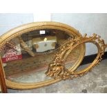 A GILT FRAMED VINTAGE OVAL WALL MIRROR TOGETHER WITH A METAL OVAL PICTURE FRAME (2)