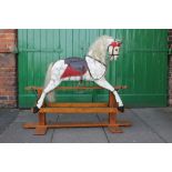 A HANDPAINTED WOODED ROCKING HORSE ON TRESTLE BASE