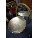 AN ANTIQUE GILT OVAL WALL MIRROR AND A BRASS TOP TABLE (2)