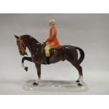 A GERMAN STYLE CERAMIC FIGURE OF A HUNTSMAN ON HORSEBACK
