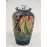 A VINTAGE MOORCROFT VASE DECORATED WITH LEAVES AND BERRIES