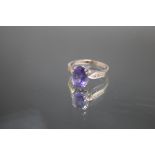 A HALLMARKED 18 CARAT WHITE GOLD TANZANITE AND DIAMOND RING, the oval Tanzanite being an estimated 2