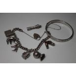 A HALLMARKED SILVER CHARM BRACELET WITH ATTACHED CHARMS, the bracelet stamped to individual links,