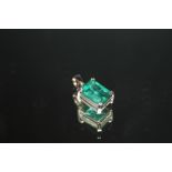 A HALLMARKED 18 CARAT WHITE GOLD EMERALD PENDANT, the emerald cut emerald being an estimated 3