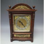 AN EARLY 20TH CENTURY OAK CASED SMALL BRACKET CLOCK, the arched case with ornate brass mounts, the