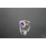 A PLATINUM SET TANZANITE AND DIAMOND RING, having a central oval Tanzanite of an estimated 2 carats,