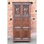 A NEO-GOTHIC OAK CARVED TWO DOOR CUPBOARD, each door with heavily carved figurative detail and