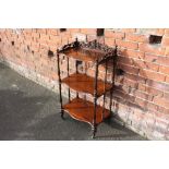 A 19TH CENTURY ROSEWOOD THREE TIER WOT NOT, the serpentine fronted tiers united by slender turned