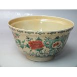 A CHINESE FAMILLE ROSE CREAM GROUND FOOTED BOWL, typical hand painted decoration with flower