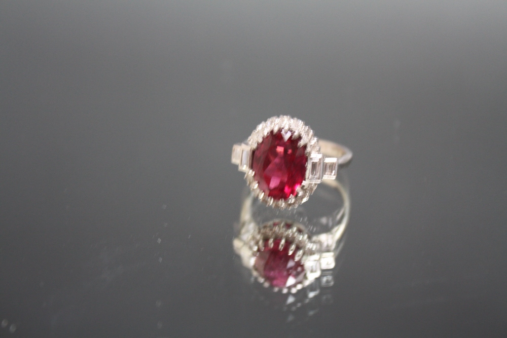 AN 18CT WHITE GOLD ART DECO STYLE DIAMOND AND RUBY TYPE RING, the central red stone measuring approx