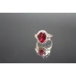 AN 18CT WHITE GOLD ART DECO STYLE DIAMOND AND RUBY TYPE RING, the central red stone measuring approx