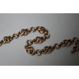 A HAND CRAFTED 9CT GOLD CELTIC KNOT STYLE BRACELET, having circular links between each 'knot' effect