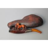 AN UNUSUAL SMALL PIPE CARVED WITH A SPANIEL RETRIEVING A GAME BIRD, with amber mouth piece and