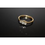 AN 18 CARAT GOLD ILLUSION SET THREE STONE DIAMOND RING