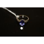 A HALLMARKED 18 CARAT WHITE GOLD TANZANITE AND DIAMOND RING, the oval Tanzanite being an estimated 2