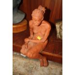 A TERRACOTTA SEATED NUDE LADY FIGURE