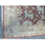 AN EASTERN WOOLLEN 20TH CENTURY RUG / CARPET, the all over floral pattern on a mainly red, yellow