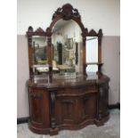 A MID VICTORIAN MAHOGANY SERPENTINE FRONTED CHIFFONIER, with carved pediments, the shaped lower