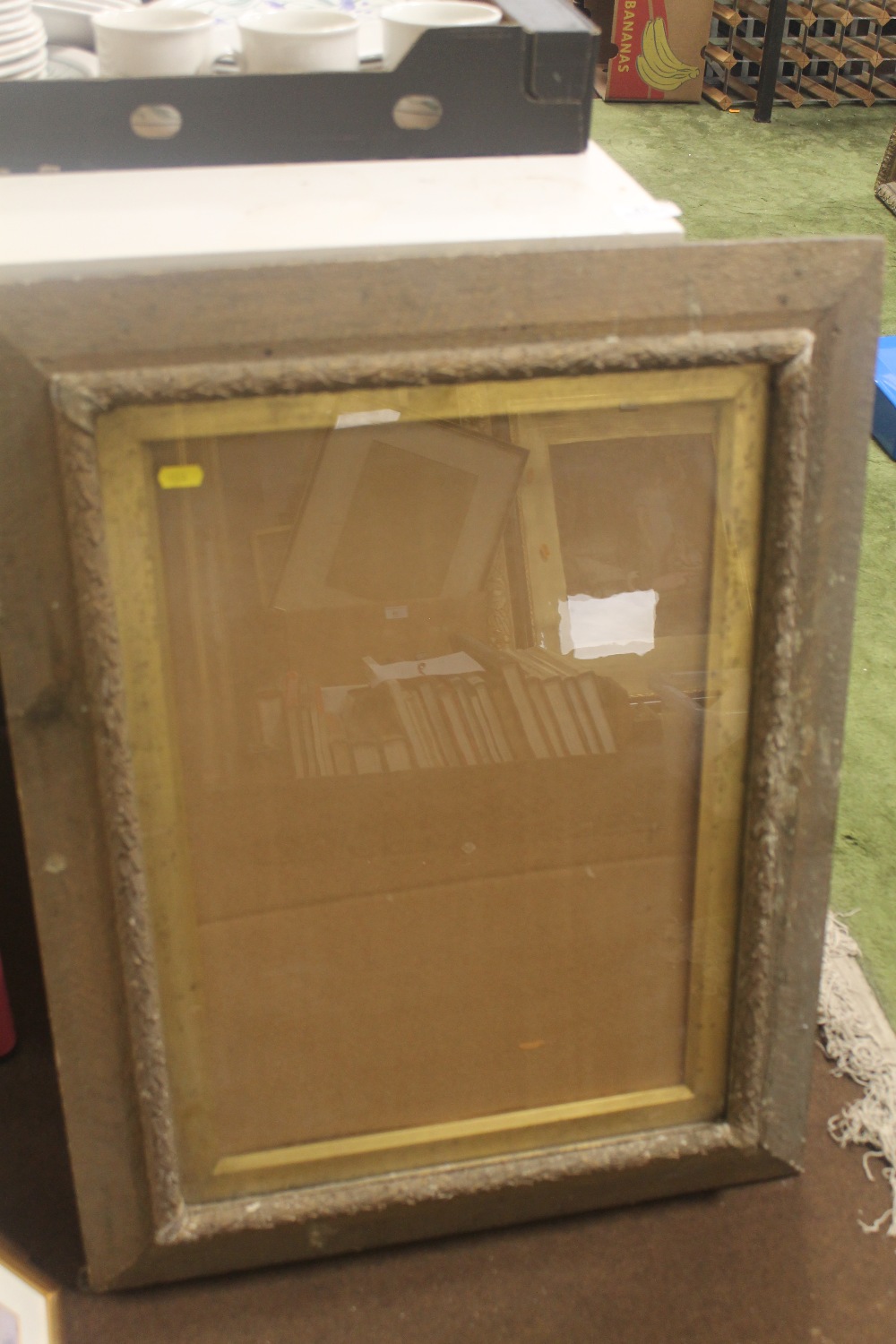 AN ANTIQUE PICTURE FRAME WITH GLASS AND DECORATIVE MOULDING