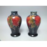A PAIR OF WILLIAM MOORCROFT POMEGRANATE PATTERN TUBE LINED SMALL VASES, of baluster form,