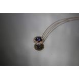 A PLATINUM SAPPHIRE AND DIAMOND PENDANT, set on a 925 silver chain, Dia. 11 mm