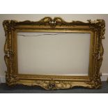 A 19TH CENTURY ORNATE GOLD SWEPT FRAME, with gold slip, frame W 11 cm, slip rebate 51 x 85 cm, frame