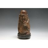 A CHINESE CARVED BAMBOO FIGURE OF AN IMMORTAL HOLDING A PEACH, H 24.5 cm