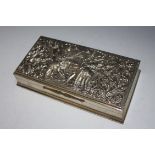 AN EASTERN STYLE SILVER CIGARETTE BOX, heavily decorated with a dual of two Thai type warriors