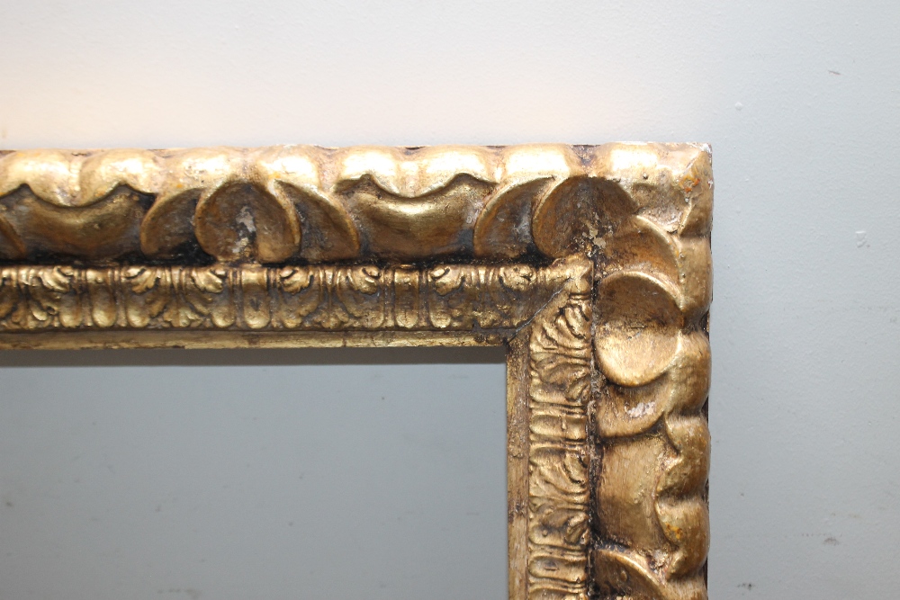 A 19TH CENTURY STYLE CARVED WOODEN GOLD FRAME, rebate 80 x 60 cm, width of frame 9 cm