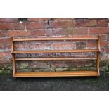 AN ERCOL TWO TIER WALL RACK, of graduating form, approximate dimensions H 50 cm, W 96.5 cm, D 13 cm