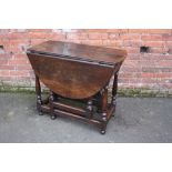 AN ANTIQUE OAK DROPLEAF TABLE, with typical gate leg mechanism, H 78 cm, Dia. 123 cm