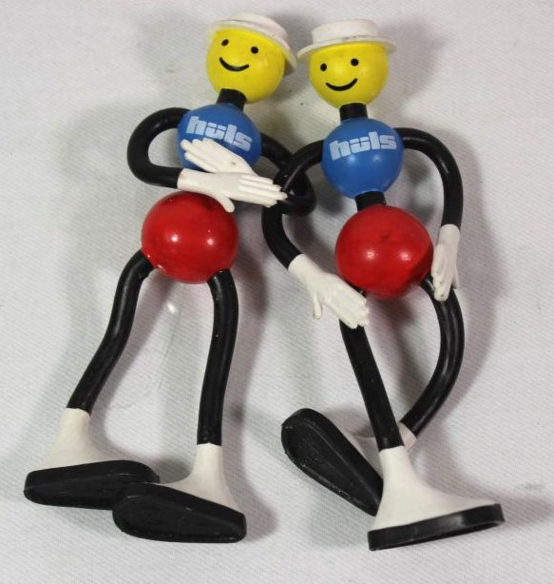 2x Werbe-Biegefiguren "Hüls", ca. H-14cm.- - -22.61 % buyer's premium on the hammer priceVAT