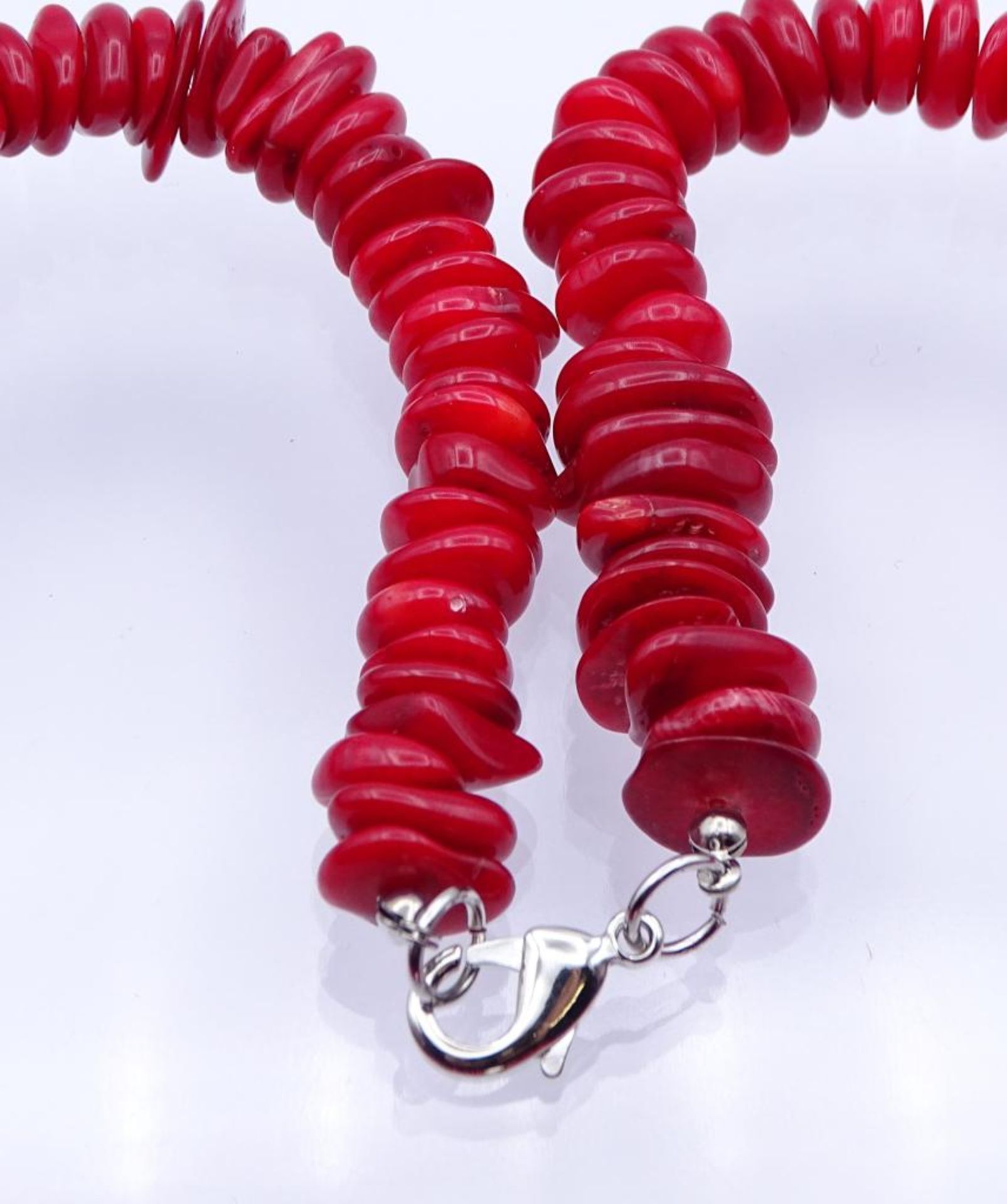Halskette, unregelmäßige Scheiben,rot gefärbte Koralle mit einer Kunstperle,versilberter Karabiner - Bild 2 aus 6