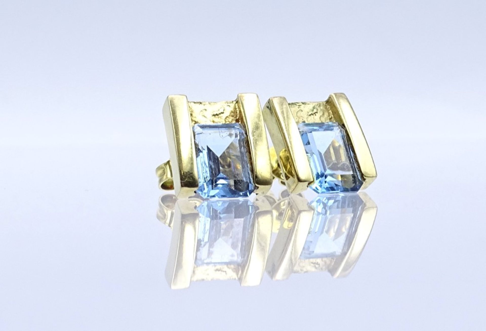 Paar GG Ohrstecker in 333er Gold, diese mit hellblauen facettierten Steinen besetzt,ges.Gew.3,5gr.,-