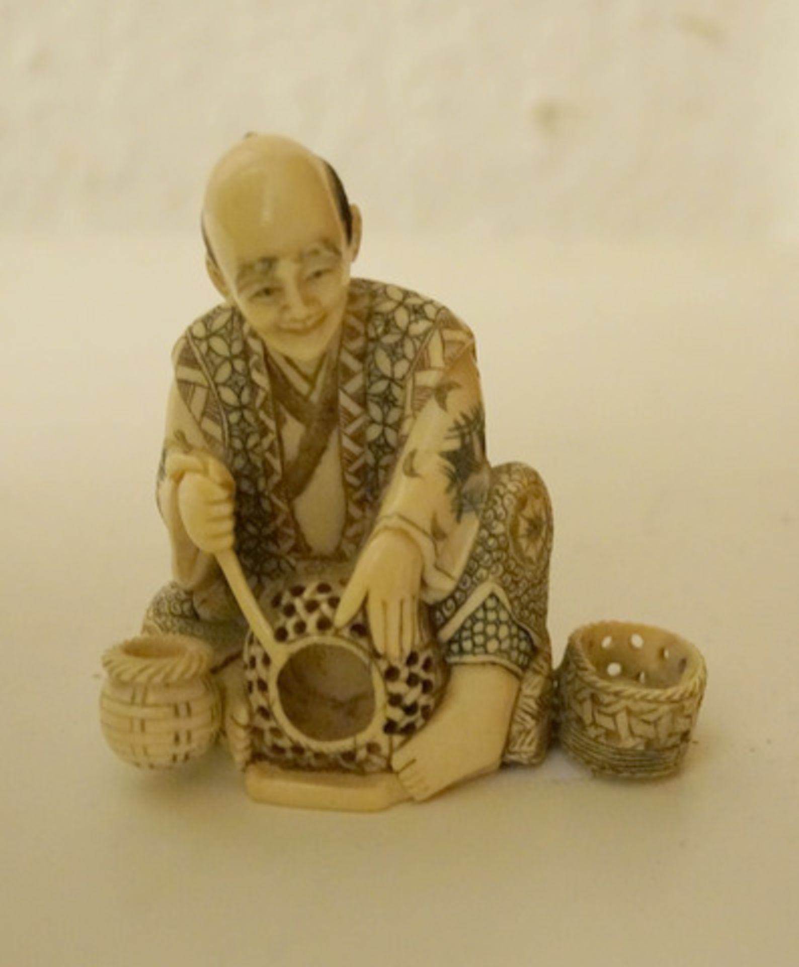 Figur eines Korbflechters, Japan, 1. H. 20. Jhd.Elfenbein geschnitzt und farbig gebeitzt, Höhe