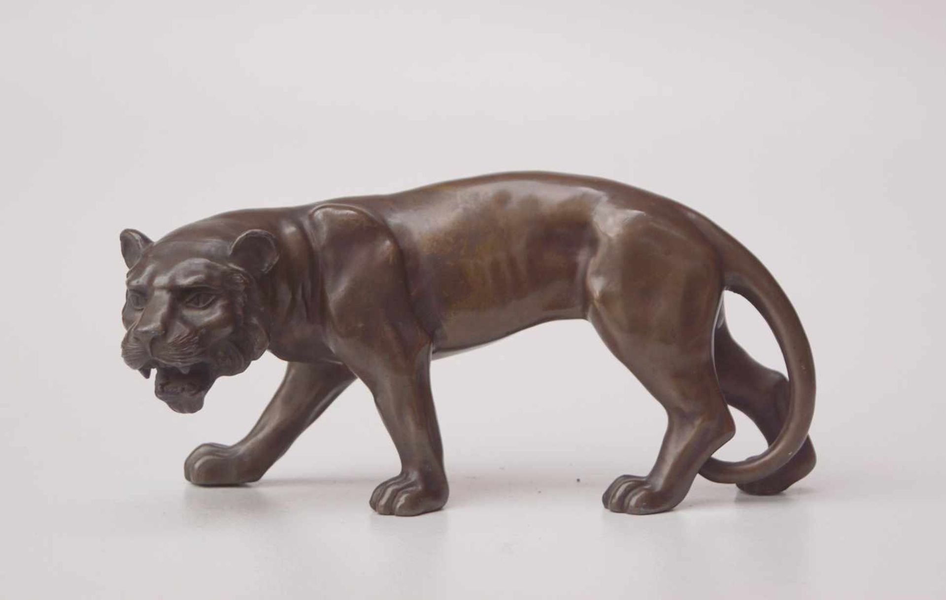 Schreitende Löwin in Angriffshaltung, um 1920Regule mit Bronzepatinierung, Länge: 27cm, Höhe: 12cm.-