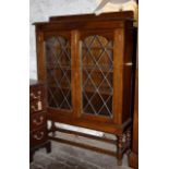 Two door oak leaded glass book case on barley twist legs with stretcher