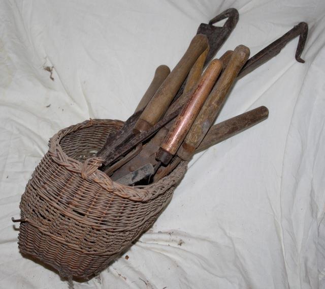 Wicker basket containing vintage gardening tools