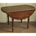 Antique French fruitwood drop leaf circular table on turned legs