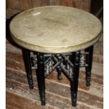 Antique Benares ware circular brass table on ornately turned, ebonised base