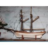 Two masted wooden sailing boat model on stand