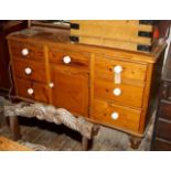 Stripped pine dresser base with 7 drawers having white china knobs