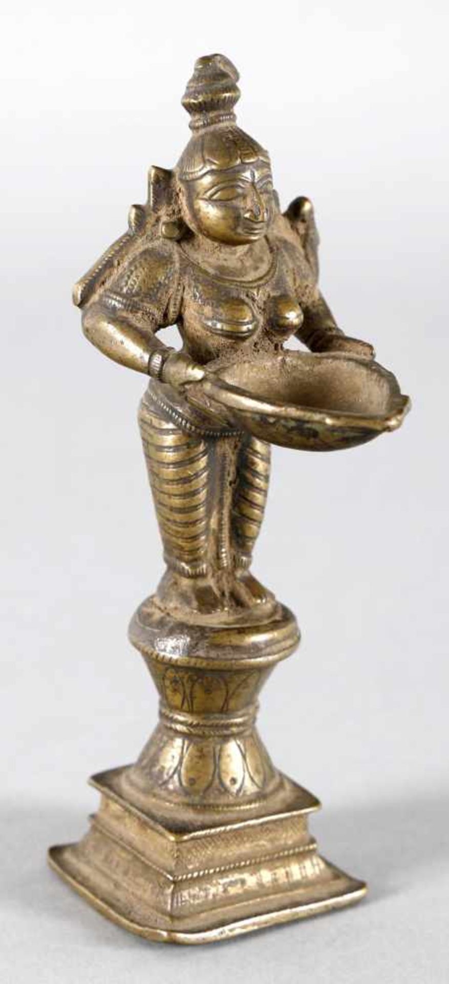 Laksmi-Öllampe aus Bronze, Südostasien, wohl 19./20. Jh.die auf einem mehrstufigen Sockel aufrecht